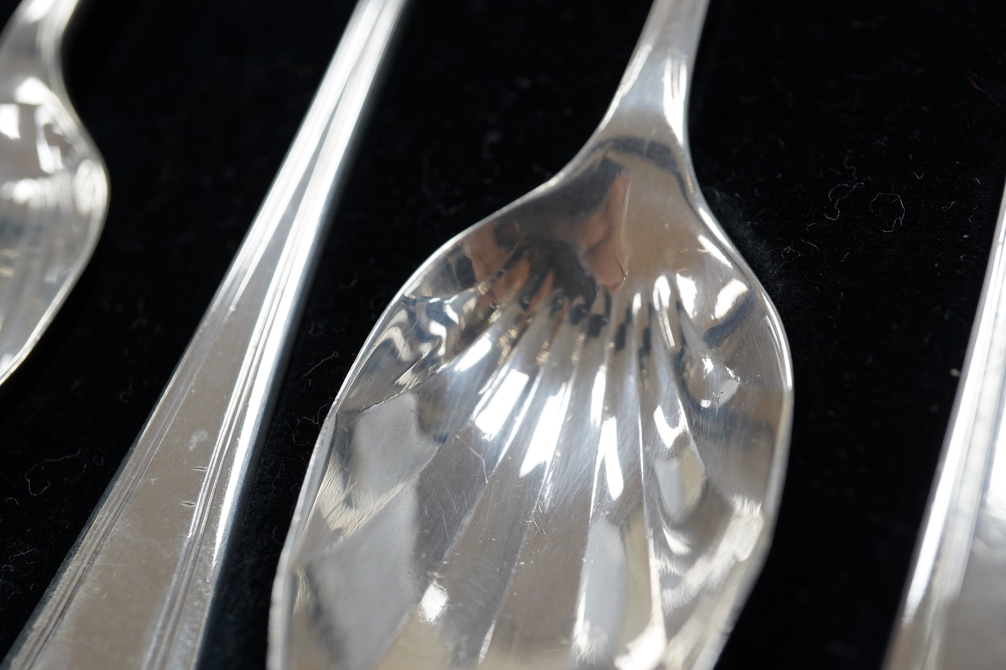 A cased set of eight George V silver grapefruit spoons, Sheffield, 1933 and a pair of silver spill vases, 17.5cm. Condition - poor to fair